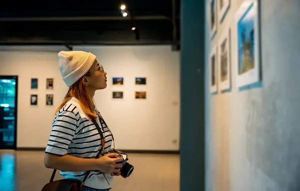 Woman holding camera in art gallery collection